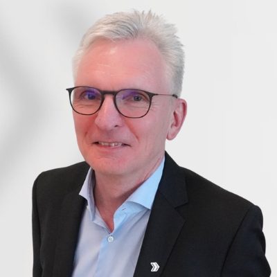 Das Foto zeigt unseren Personalberater Andreas Claussen aus der Region Baden-Baden in einem schwarzen Anzug und blauem Hemd
